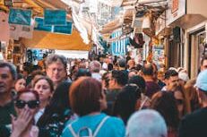 Bustling street market in Athens with diverse crowd and lively atmosphere.